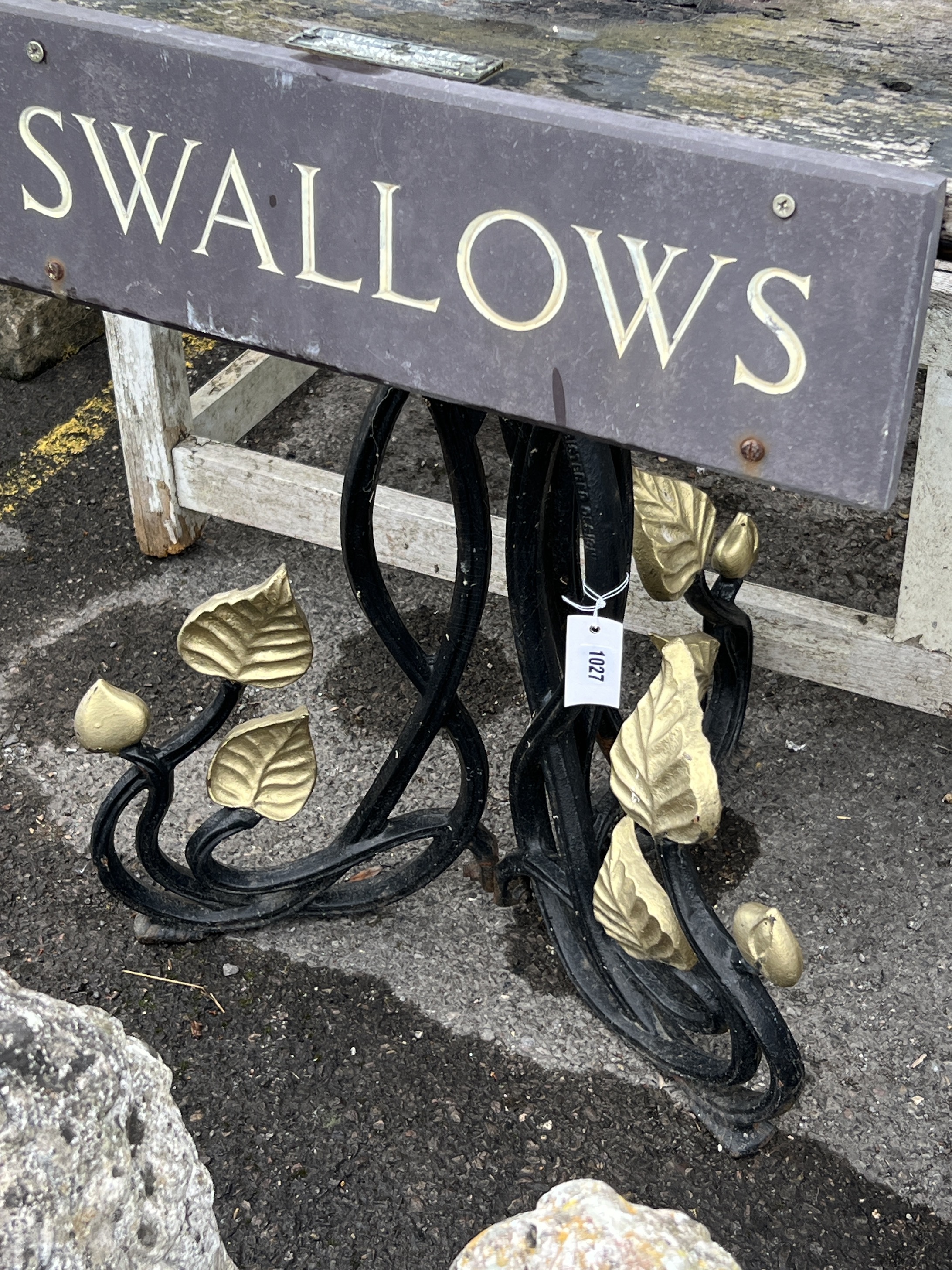 A rectangular cast iron and weathered teak garden table with a sign reading 'Swallows', width 91cm, depth 53cm, height 71cm